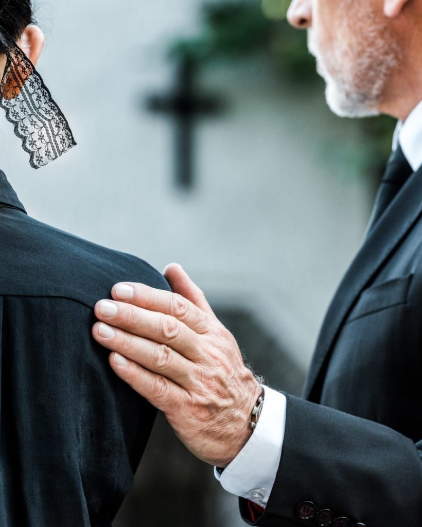 cropped-view-of-man-touching-woman-on-funeral-e1636904690263.jpg